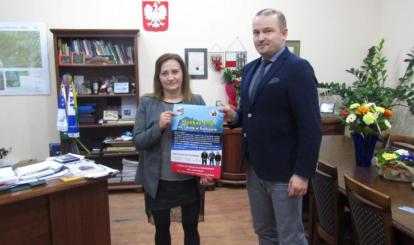 Burmistrz Połczyna-Zdroju przekazuje materiały promocyjne Katarzynie Włodarskiej na początku akcji zbierania środków
