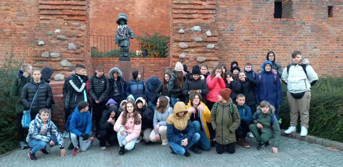 Wspólne zdjecie uczestników wycieczki w Warszawie pod Pomnikiem Małego Powstańca